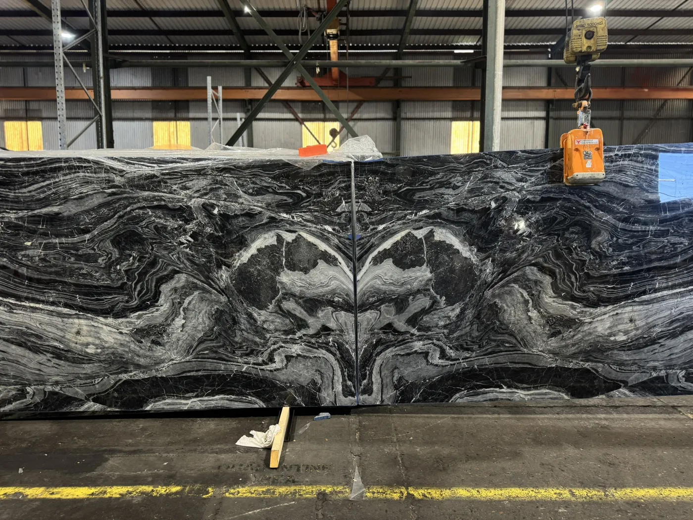 Dark slab with dramatic white and grey movement standing in a warehouse