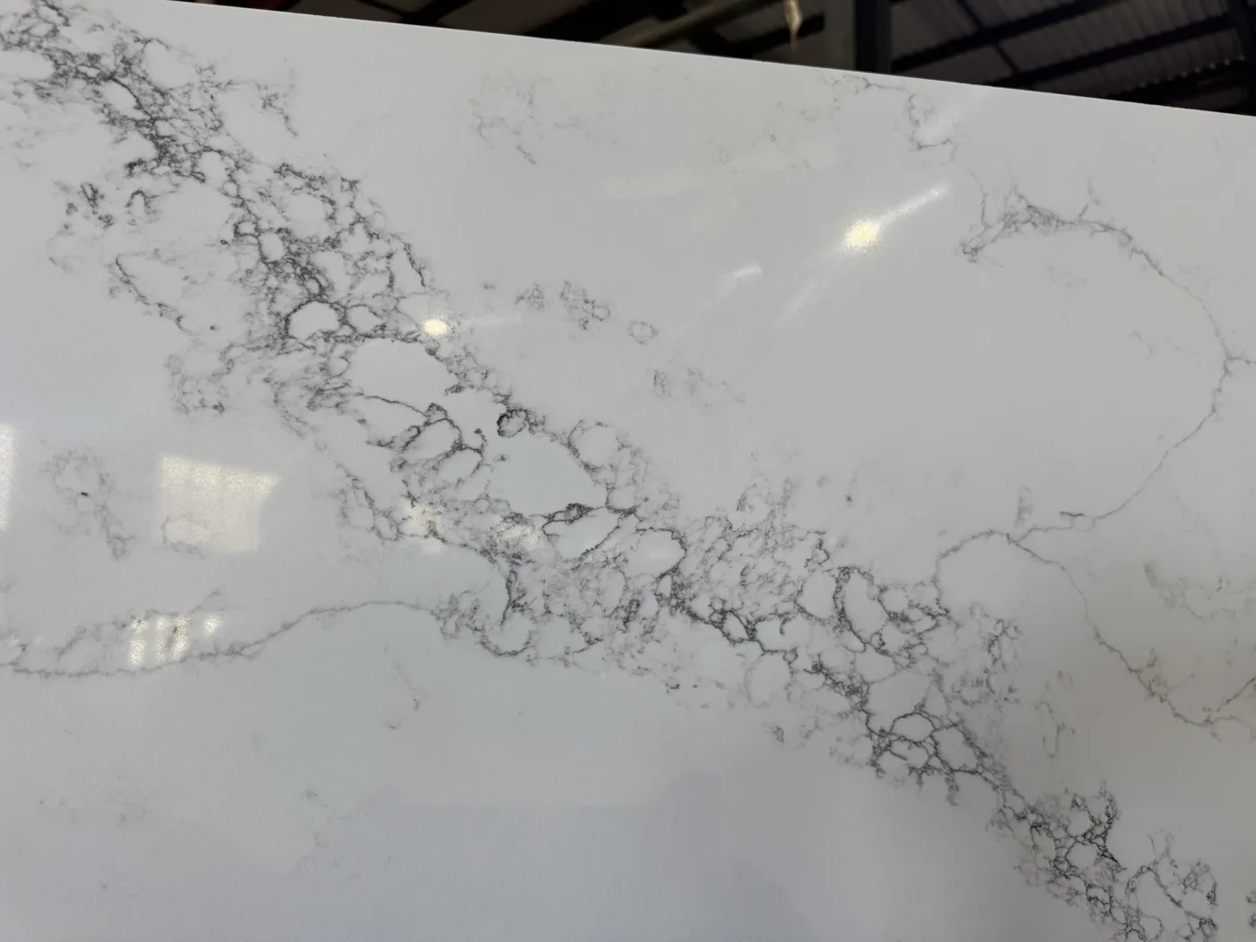 Close view of grey veining across a polished white slab